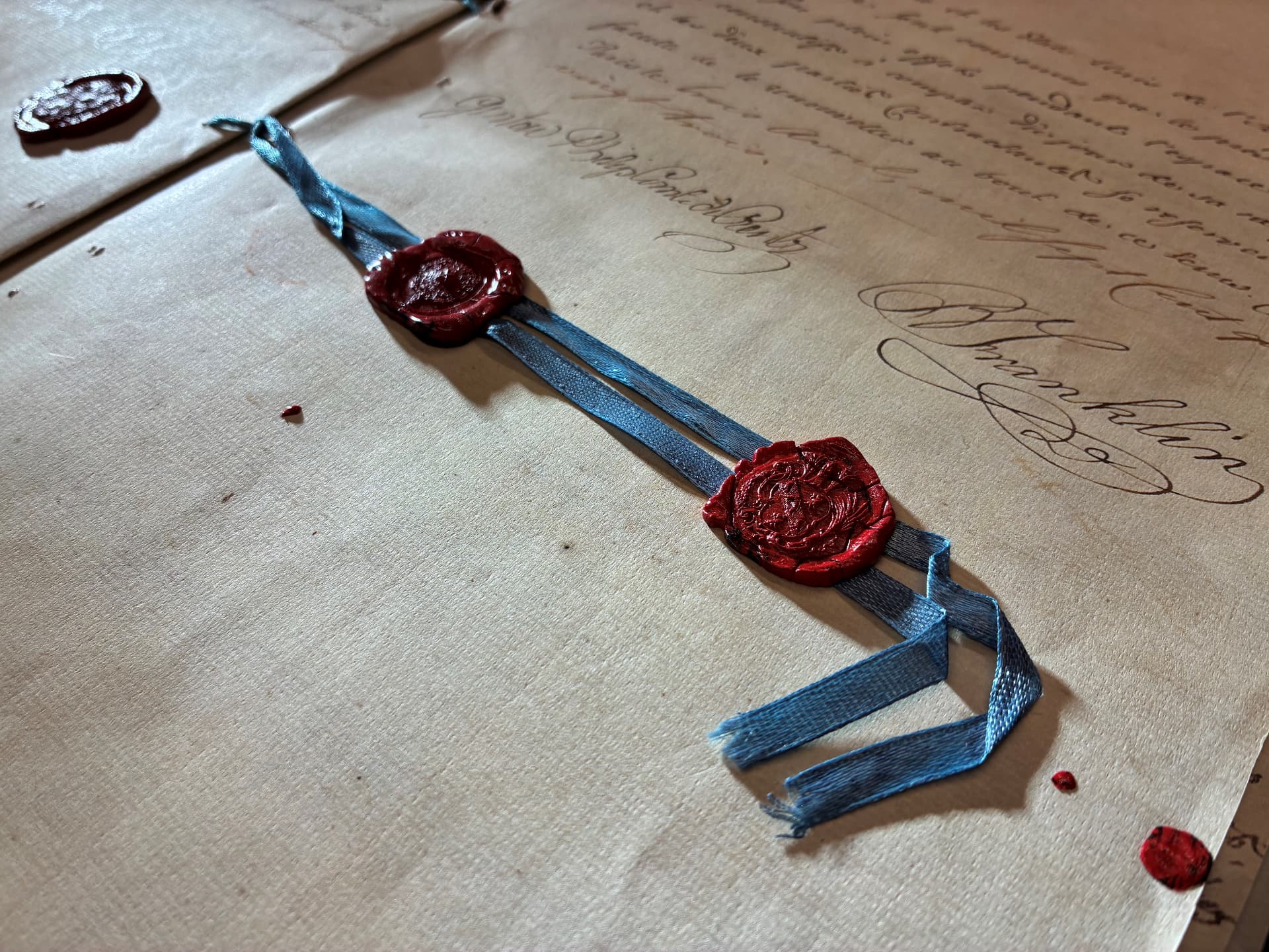 Historiskt dokument med röda lacksigill och blått band