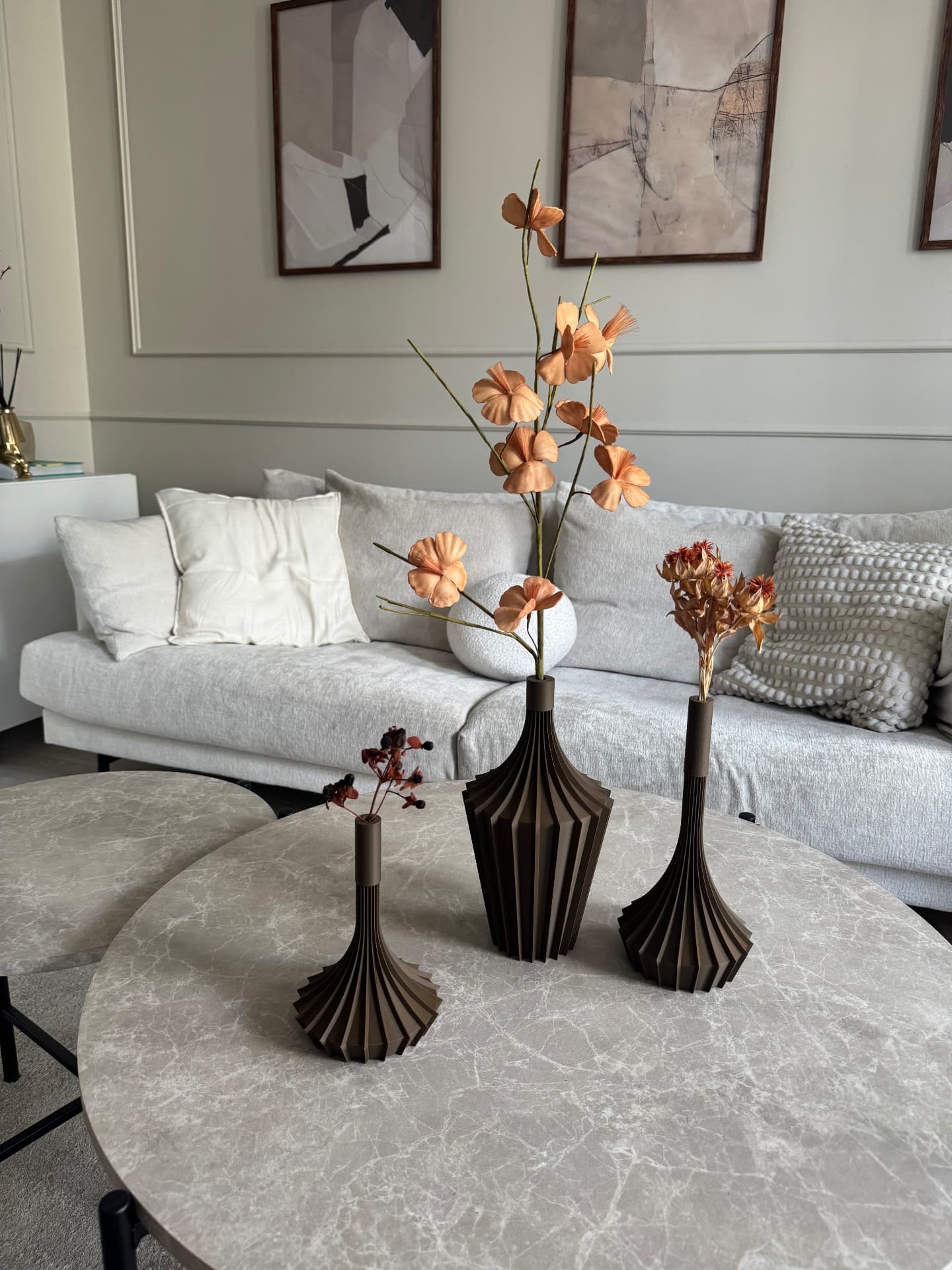 Tre bruna 3D-printade vaser med torkade blomsterarrangemang